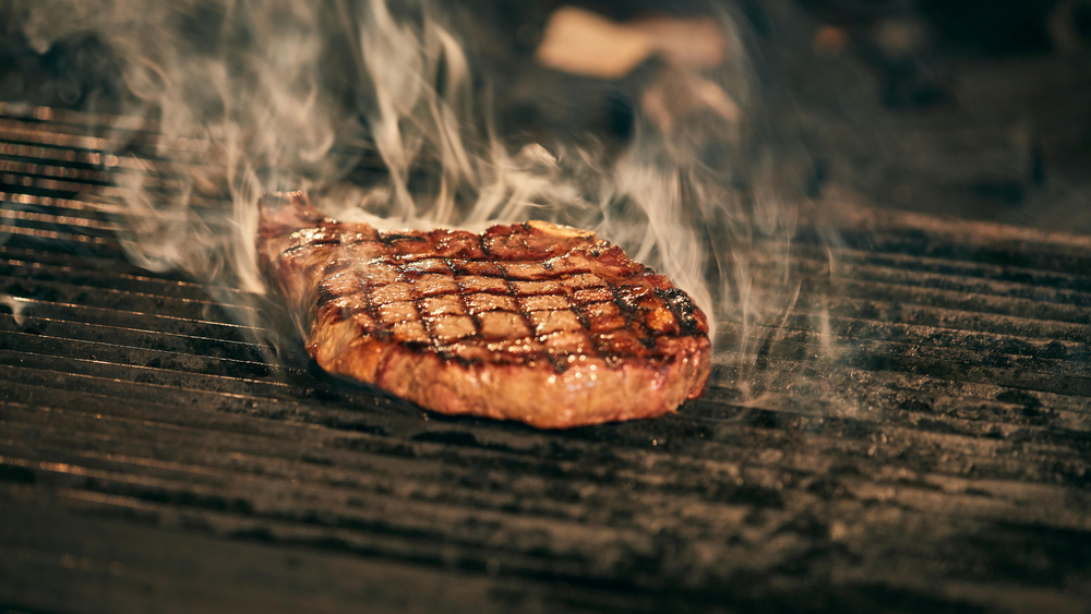 Juicy Good Ranchers Steak Searing On A Hot Grill With Smoke