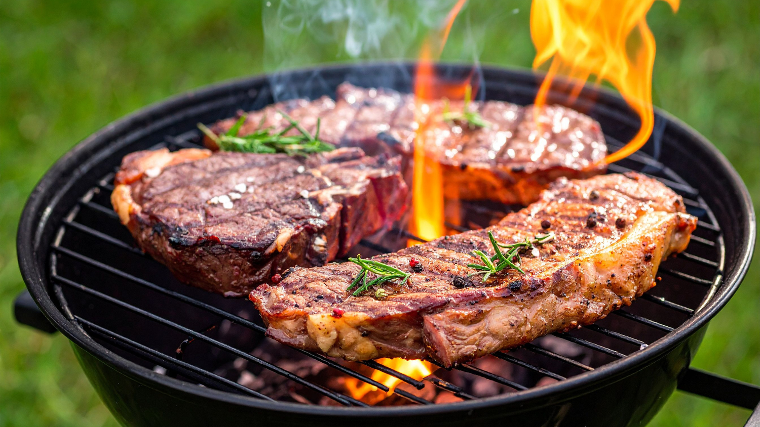 Juicy steaks grilling over open flame with perfect char on a round charcoal grill