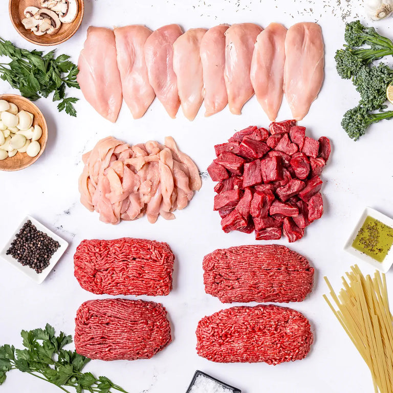 The Essentials Box includes free range chicken breasts, sliced chicken, locally sourced steak tips, and ground beef. Here is a layout of all those cuts, with mushrooms, herbs, spices, garlic, olive oil, salt, and uncooked pasta surrounding it.